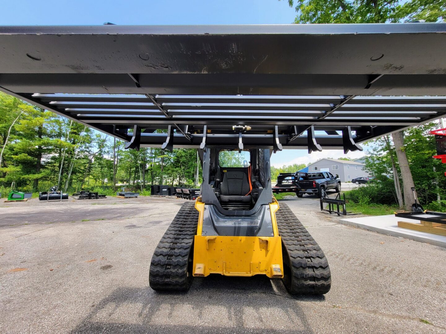 A yellow and black tractor parked in the middle of a parking lot.