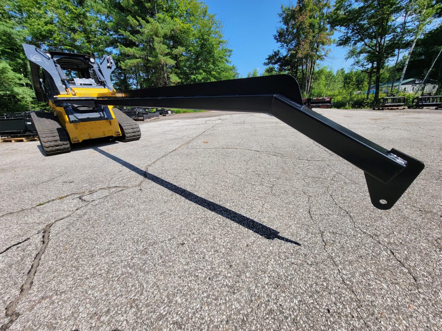 A yellow and black tractor is parked in the middle of a road.