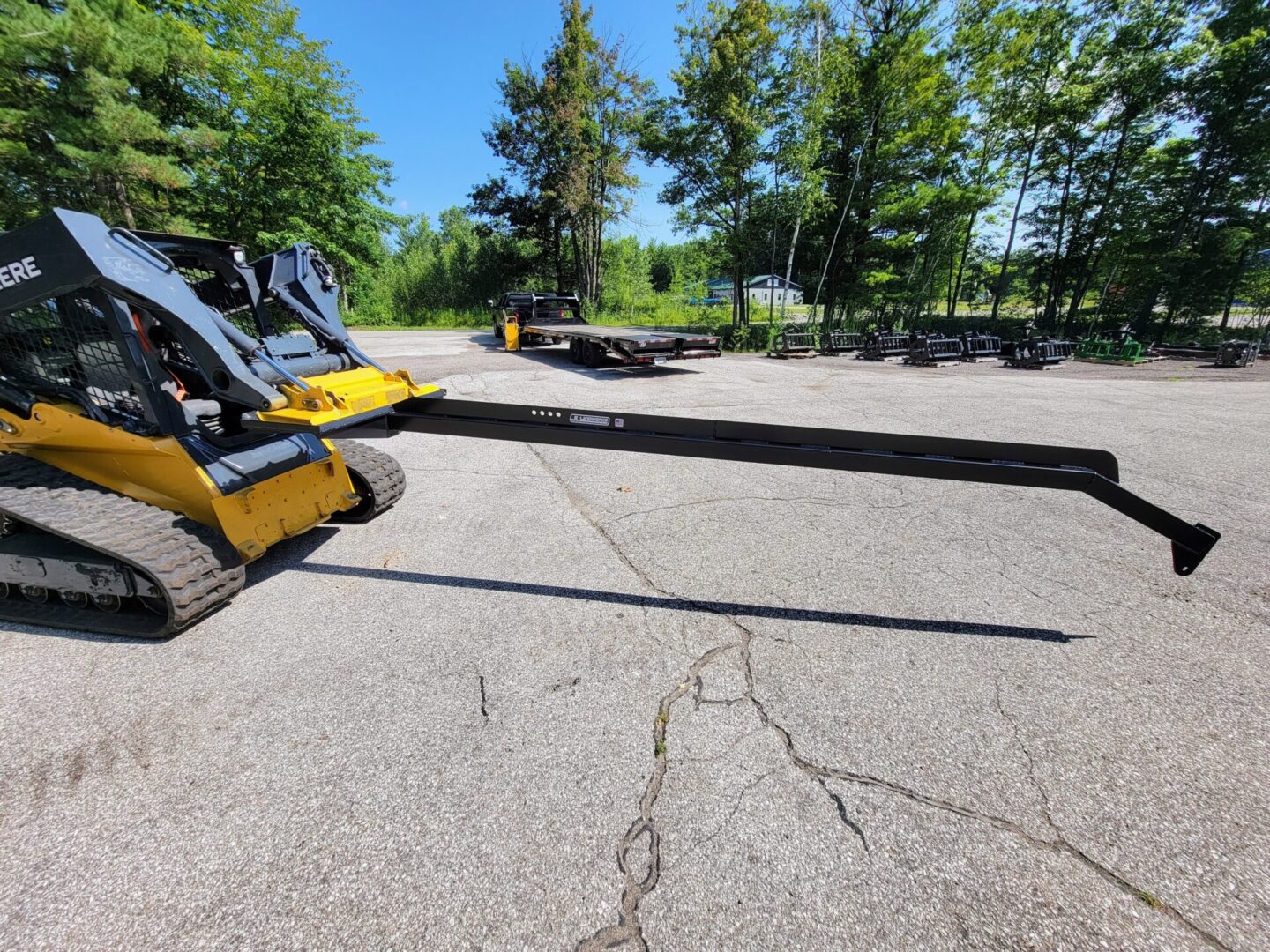 A yellow and black skid steer parked in the middle of a parking lot.