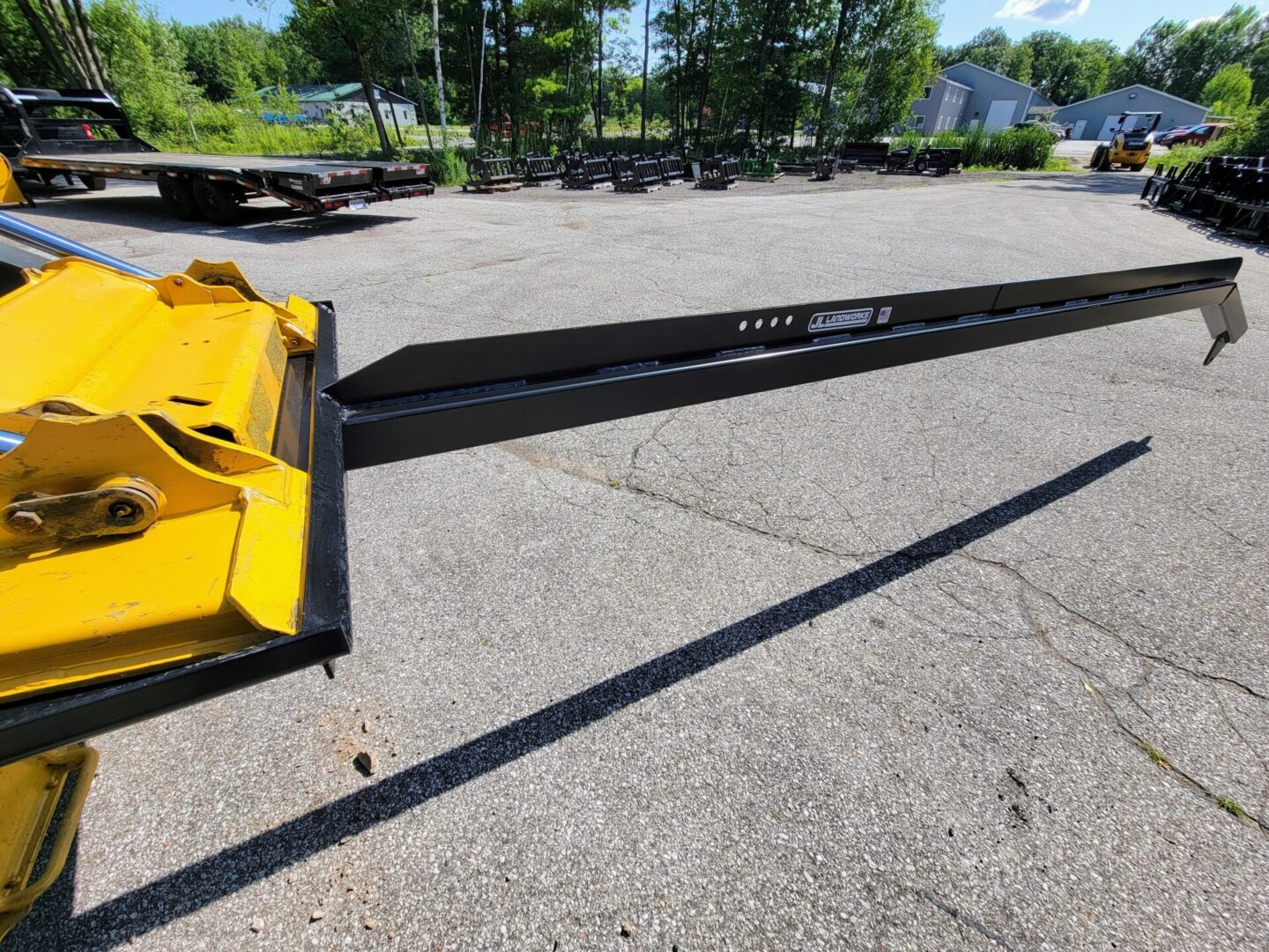 A yellow plow is parked in the parking lot.