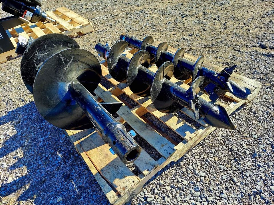 A pallet of various metal parts on top of gravel.