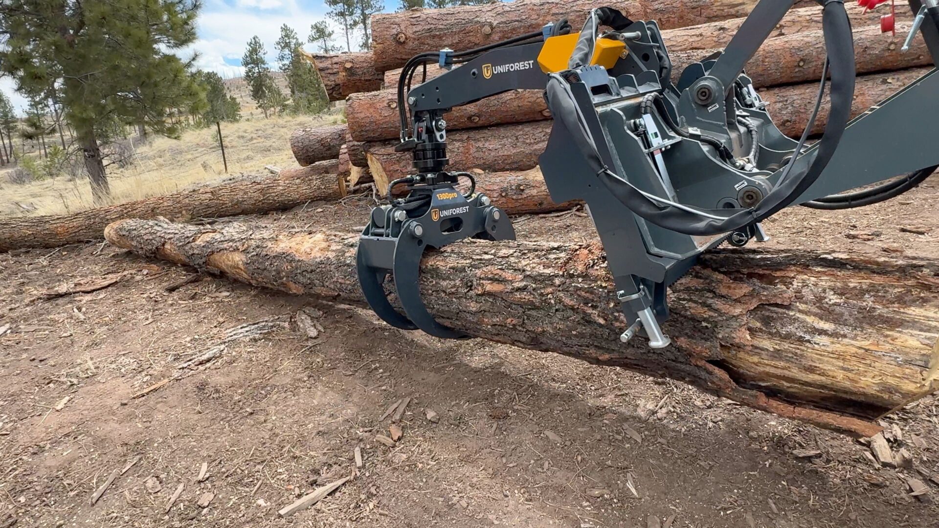 A pile of logs with a machine on it.