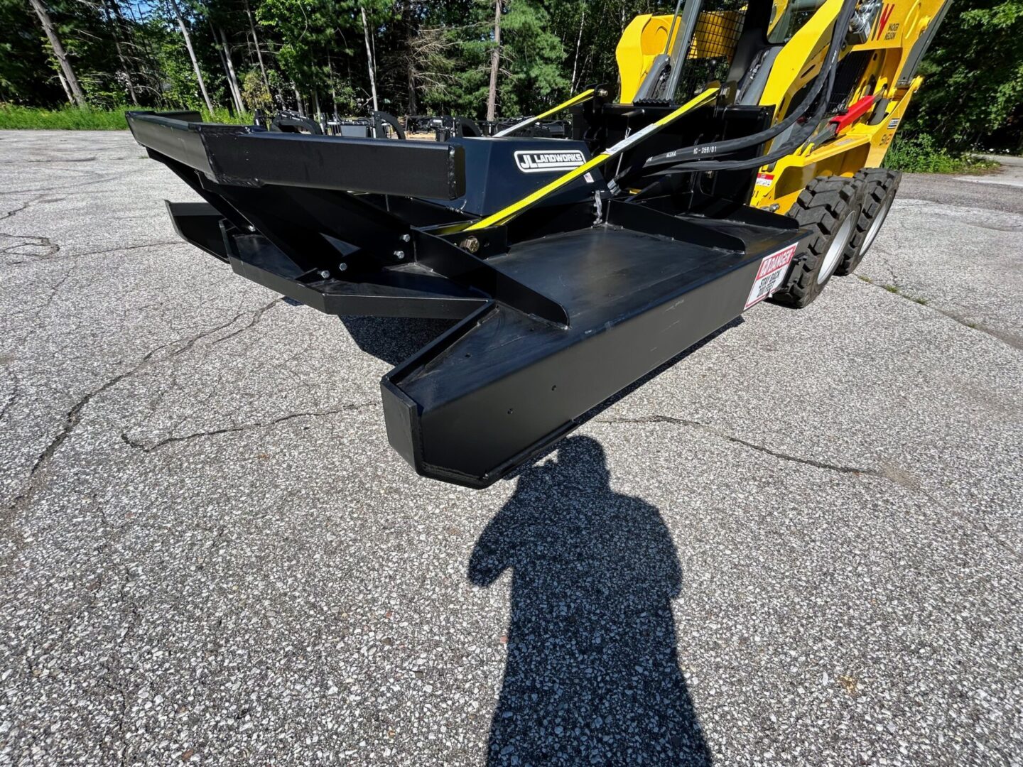 A yellow and black tractor with a plow on the back