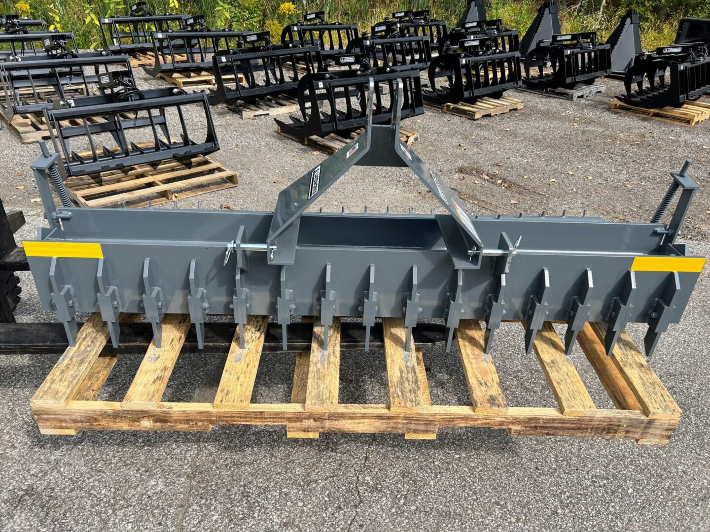 A large metal plow sitting on top of wooden pallets.