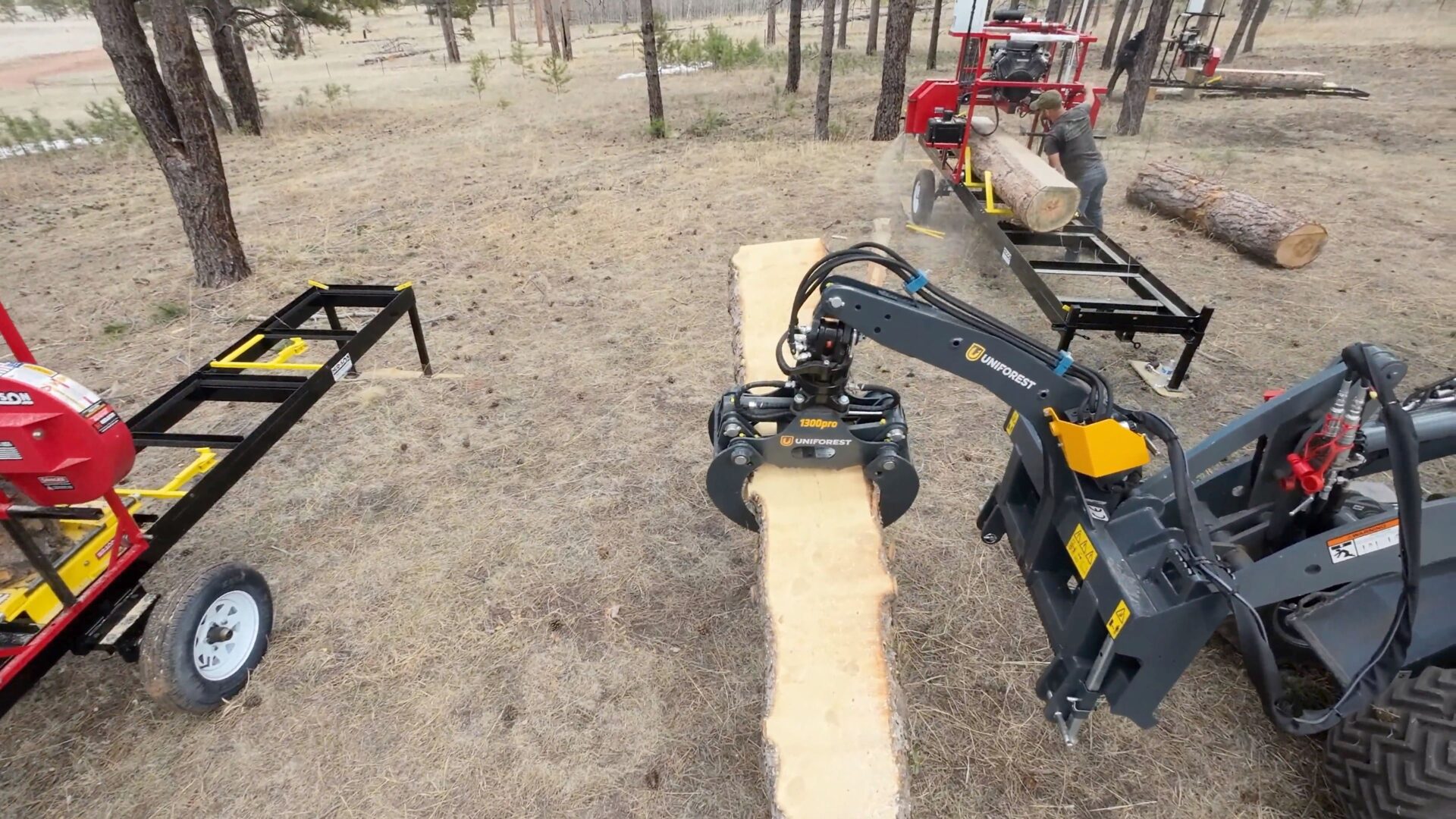 A machine that is cutting wood in the woods.