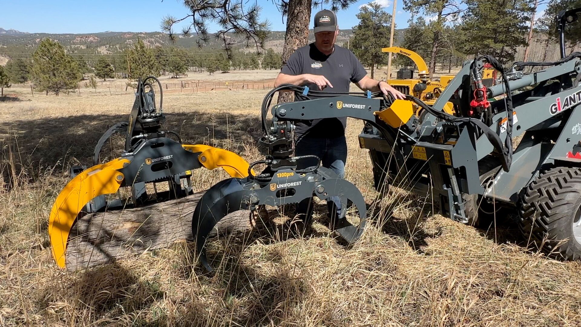 A man standing next to some machinery in the grass.