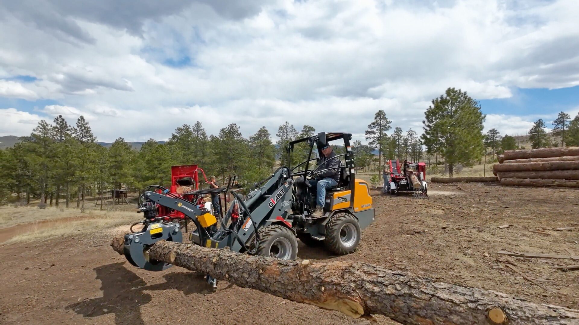 A tractor with a log handler on it in the background.