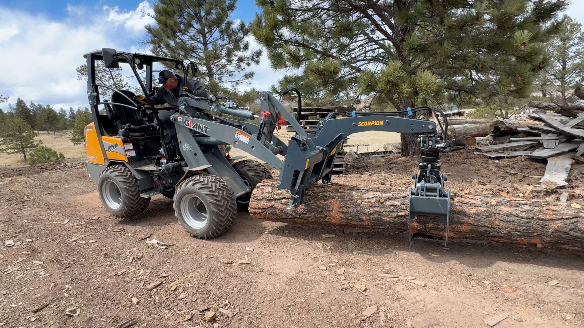 A tractor with a grapple attachment is parked on the ground.