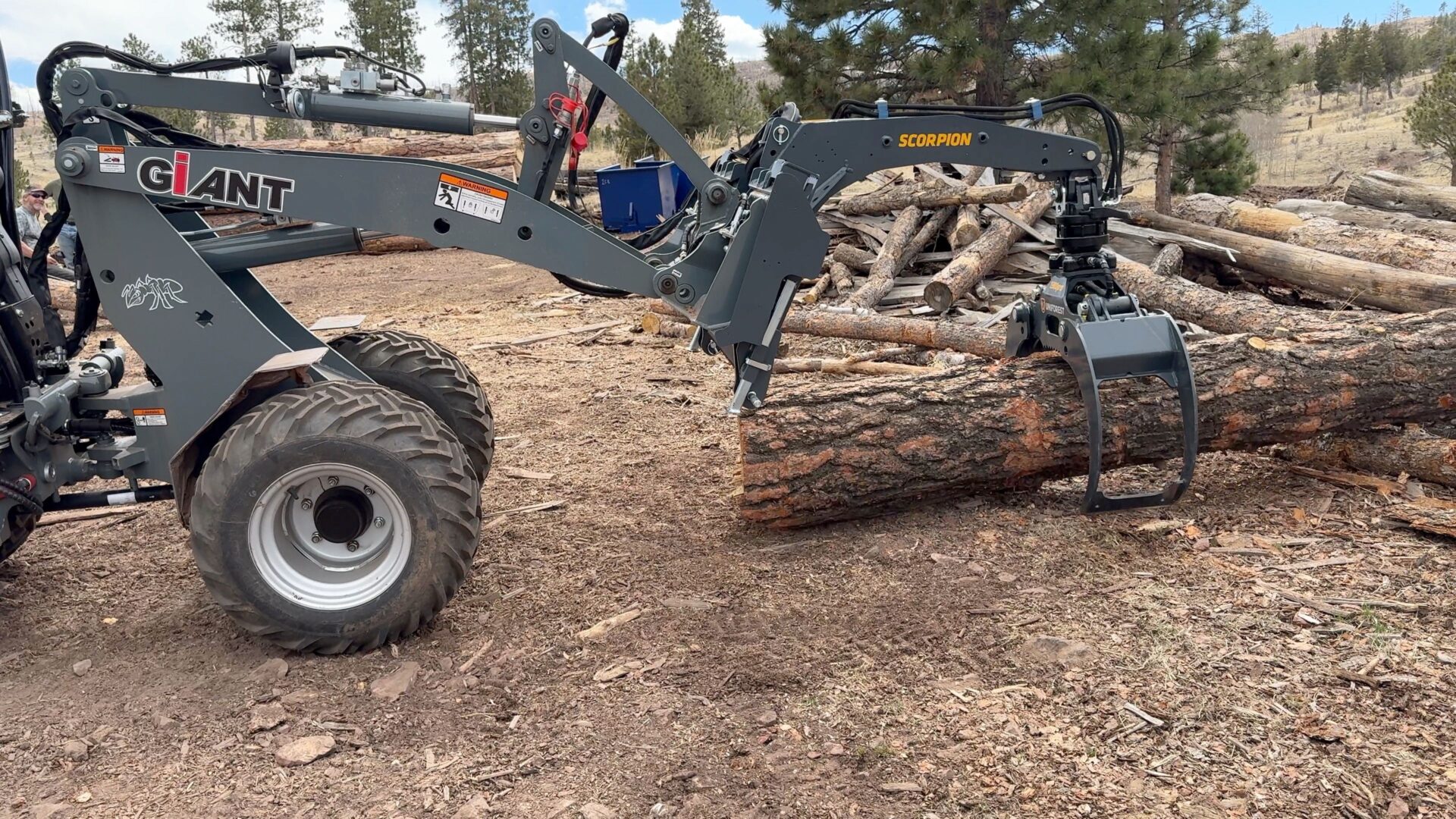 A tractor with a log handler attached to it.