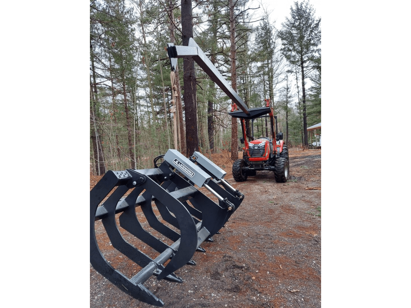 A tractor with a grapple attachment in the background.