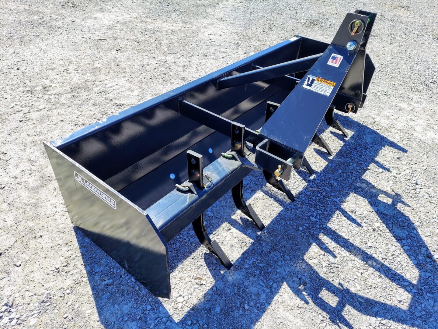 A black plow sitting on top of a cement ground.