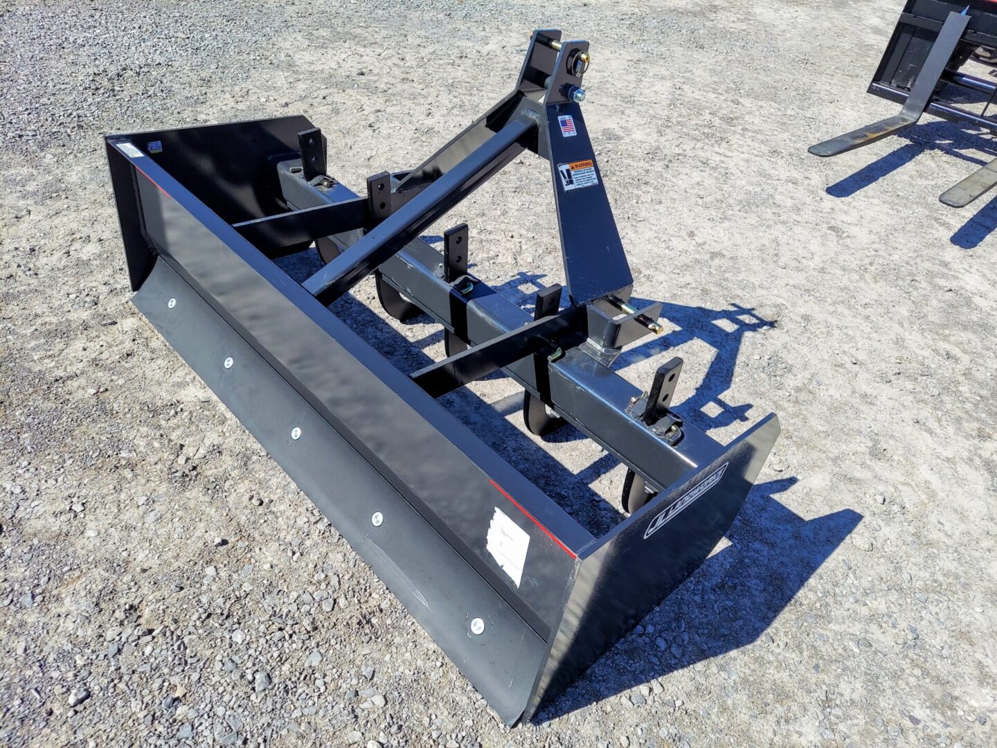 A black plow sitting on top of a cement ground.