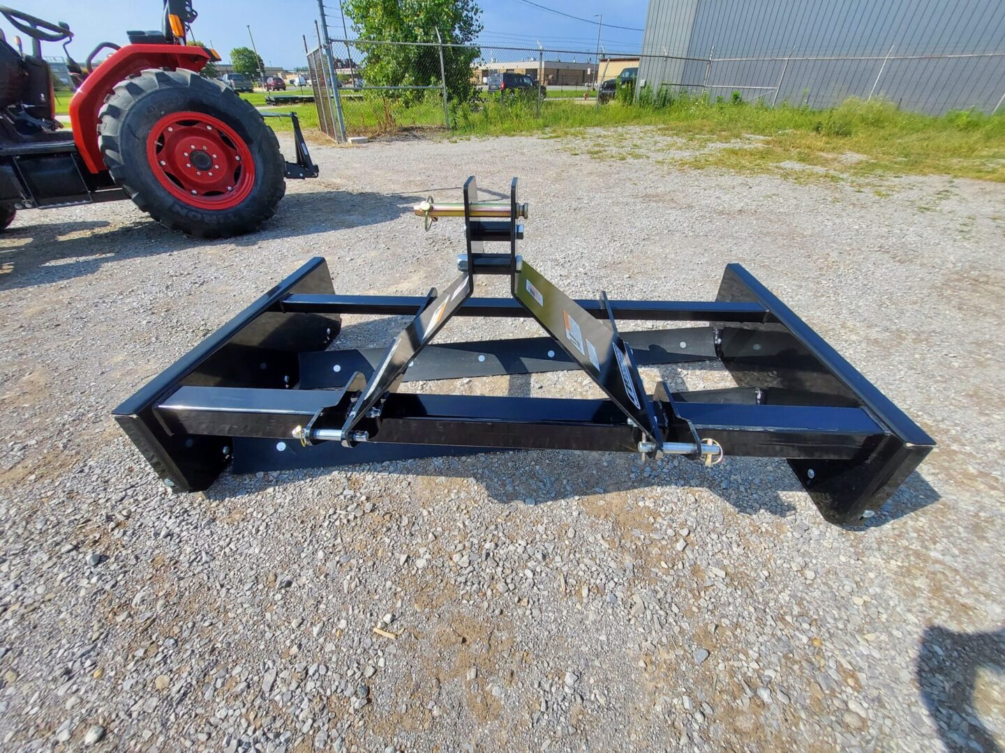 A tractor with two metal frames on the ground.