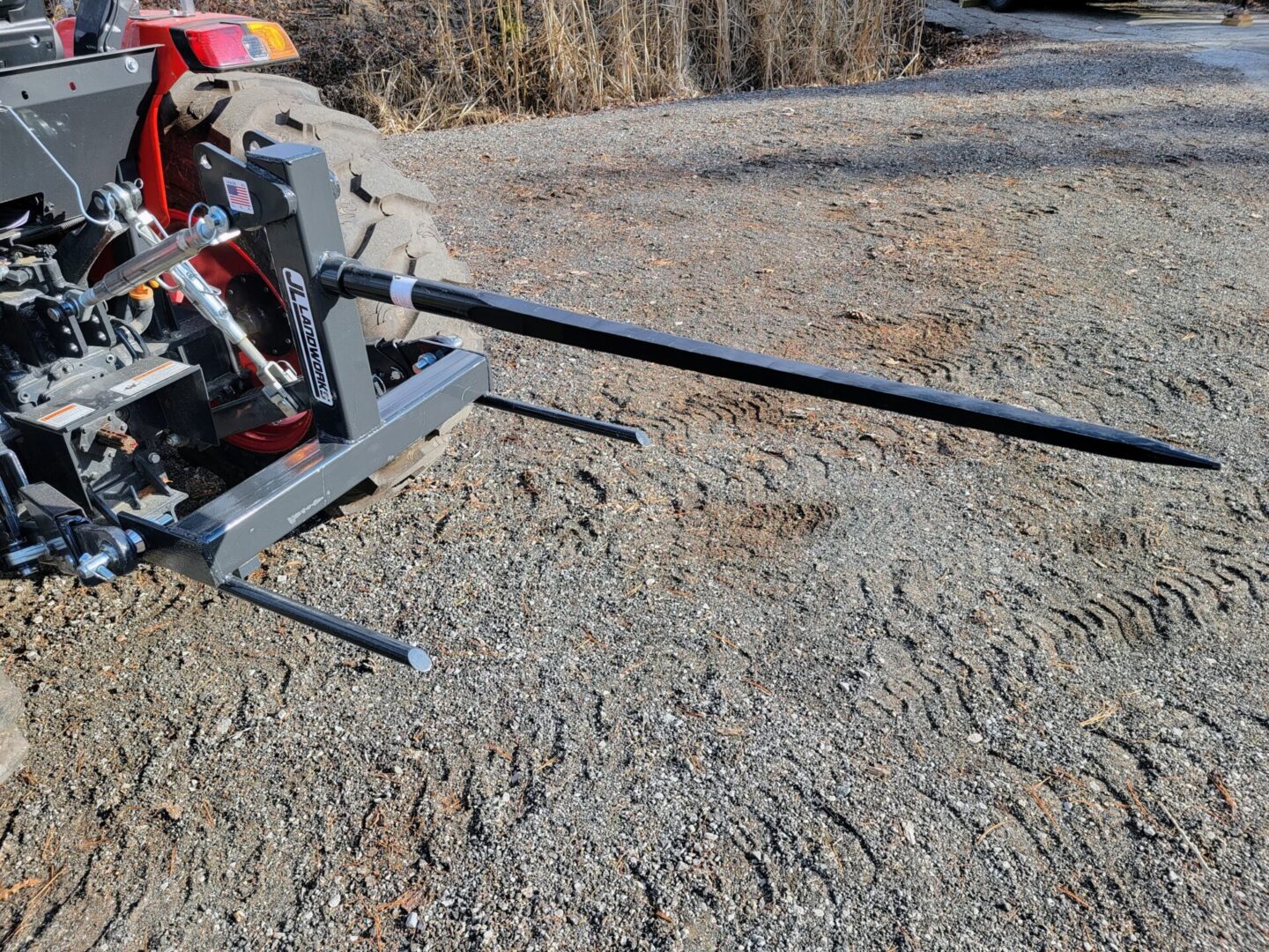 A tractor with two forks on the ground.