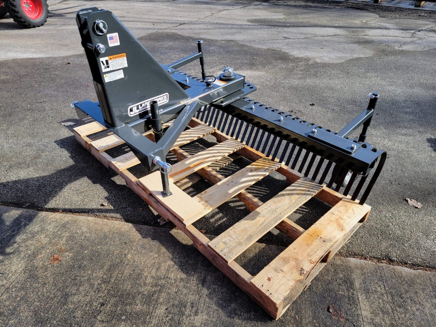 A pallet with a fork attachment and a hay rake.