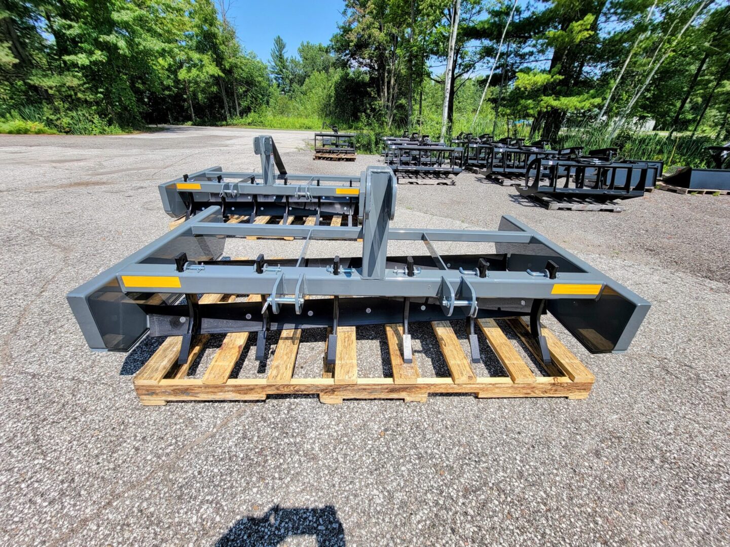 A large metal plow sitting on top of wooden pallets.