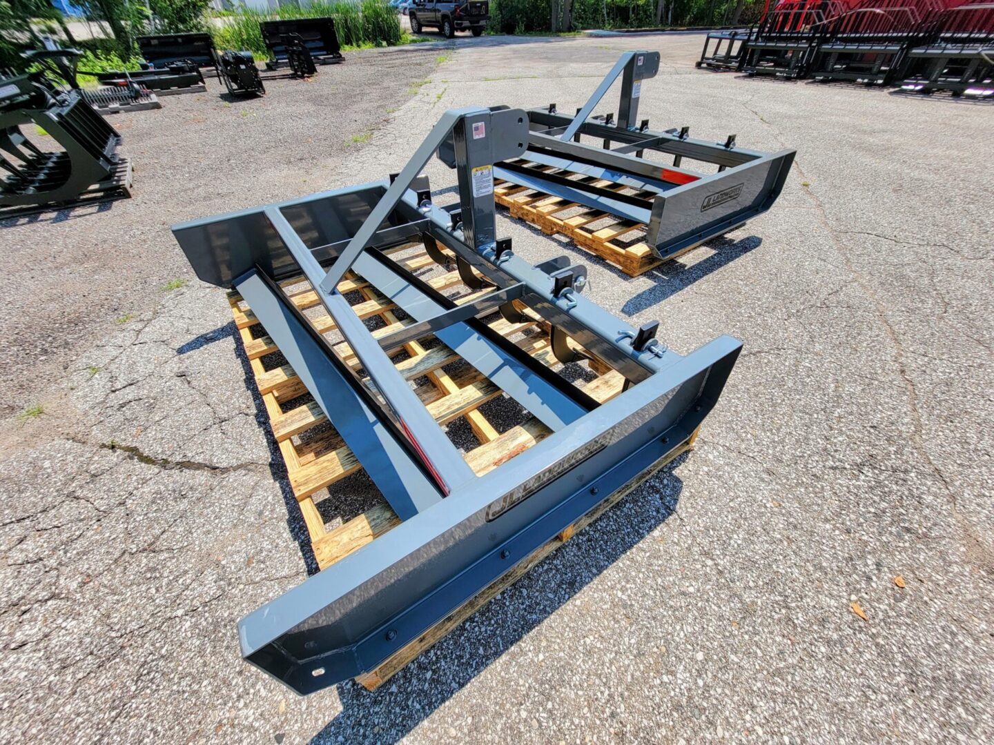 A blue trailer with some wood on the ground